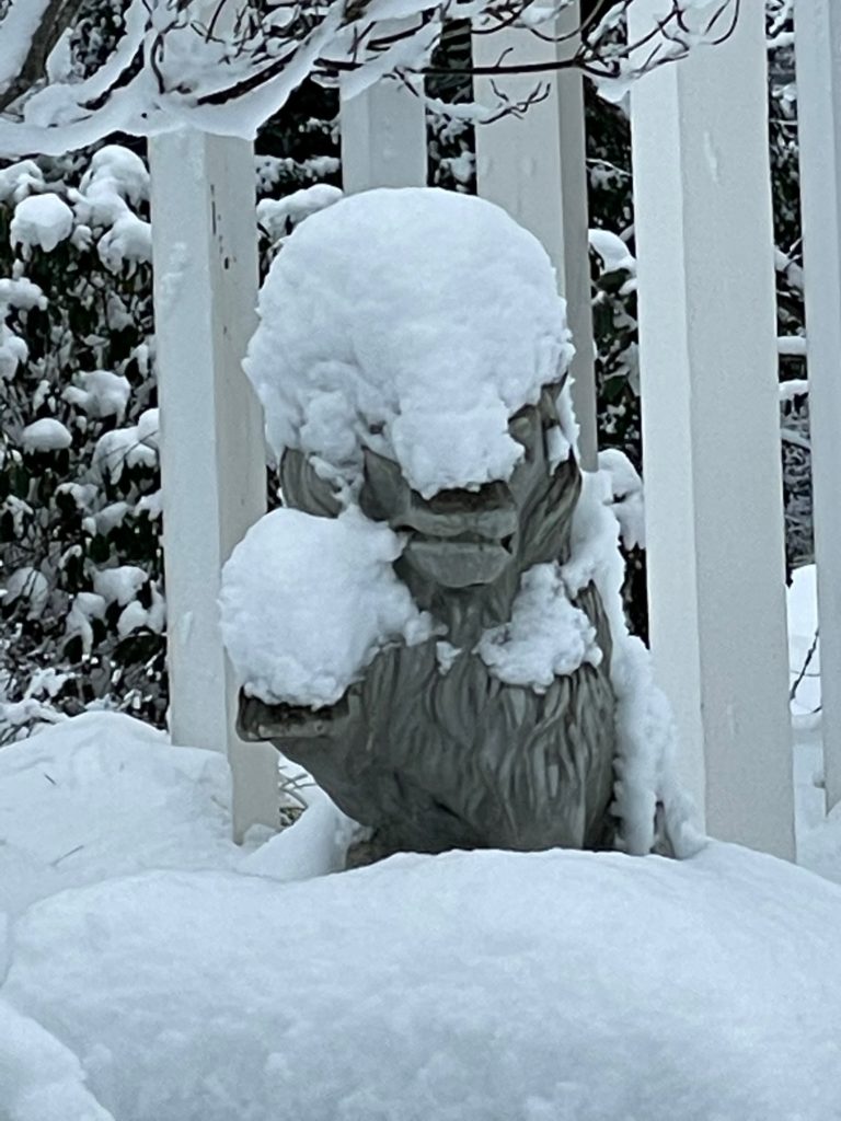 statue of lion nearly covered with snow