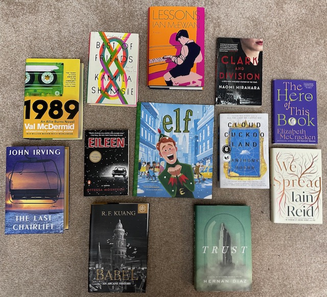 A layout of book covers: 1989 by Val McDermid; Best of Friends by Kamila Shamsie; Eileen by Otessa Moshfegh; The Hero of This Book by Elizabeth McCracken; Clark and Division by Naomi Hirahara; Cloud Cuckoo Land by Anthony Doerr; The Last Chairlift by John Irving; Lessons by Ian McEwan; Ely by David Berenbaum; We Spread by Iain Reid; Trust by Herman Diaz; Babel by R.F. Kuang