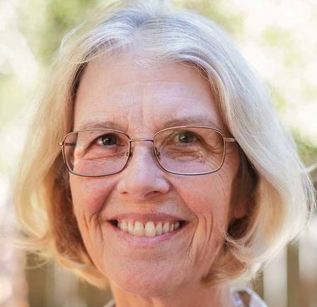 Headshot: Jane Smiley. An older woman with light skin, gray short hair, and wire-rimmed rectangular glasses.