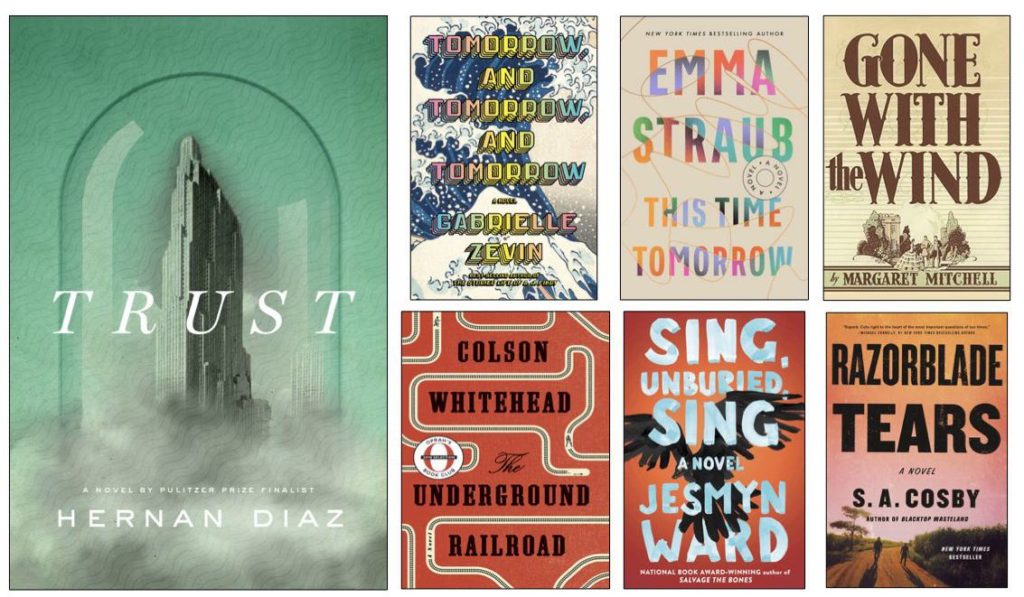 Left: large book cover, Trust by Hernan Diaz. Right: 2 rows of book covers, each half as tall as Trust. Top row, left to right: Tomorrow and Tomorrow and Tomorrow by Gabrielle Zevin; This Time Tomorrow by Emma Straub; Gone with the Wind by Margaret Mitchell. Bottor row, left to right: The Underground Railroad by Colson Whitehead; Sing, Unburied, Sing by Jesmyn Ward; Razorblade Tears by S.A. Cosby.