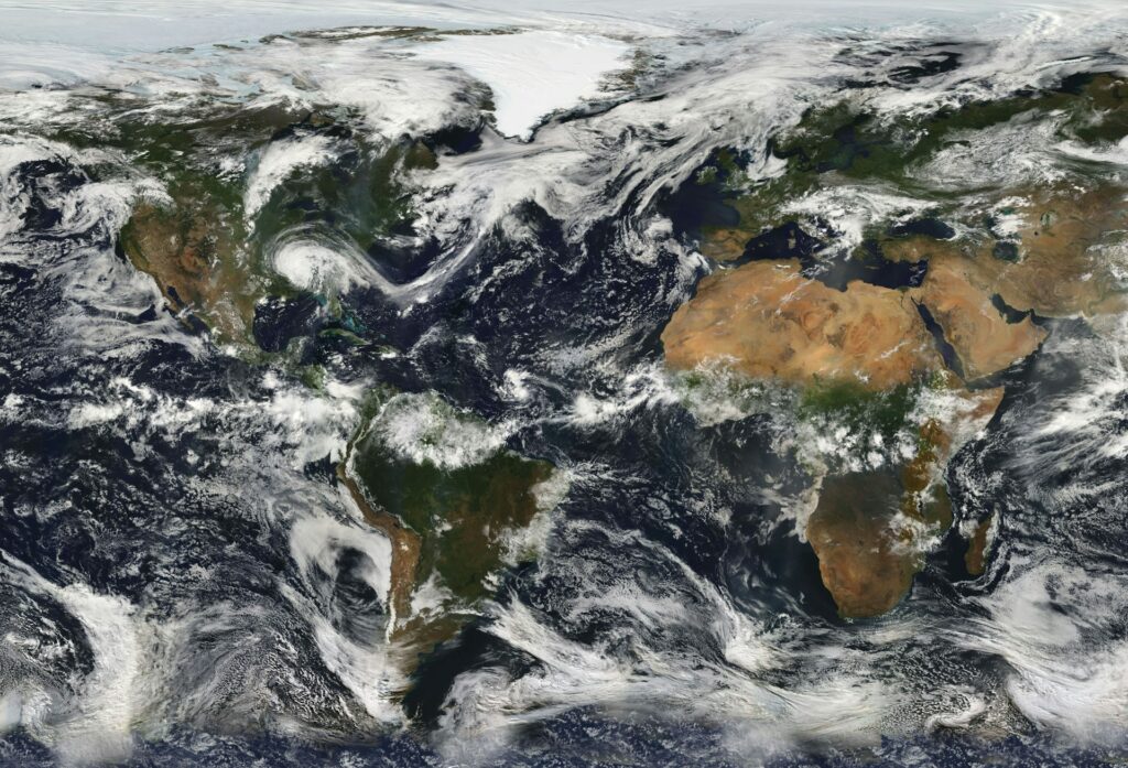 A photo taken from space. Continent of Africa (brown) is visible, surrounded by blue ocean; white clouds partially obstruct the other continents.